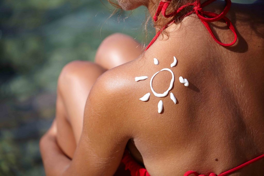dos de femme avec soleil en crème solaire