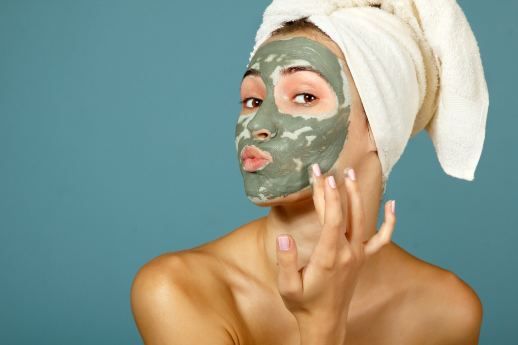 femme appliquant masque d'argile sur son visage