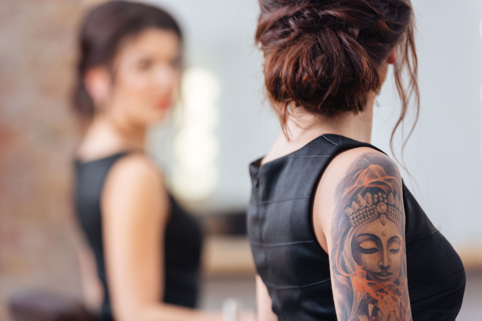 femme tatouée se regardant dans le miroir