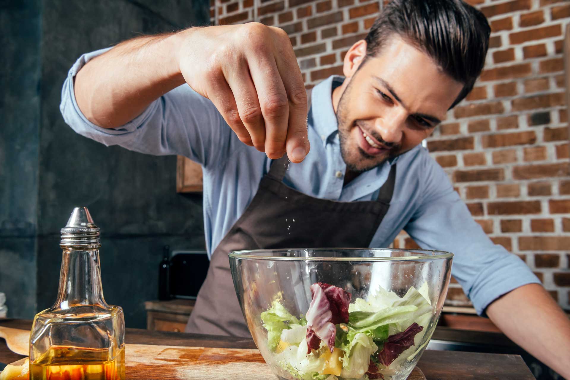 homme ajoutant du sel dans une salade