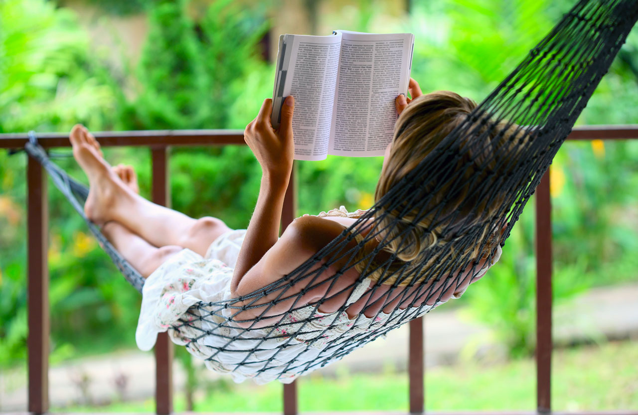 femme entrain de lire dans un hammac