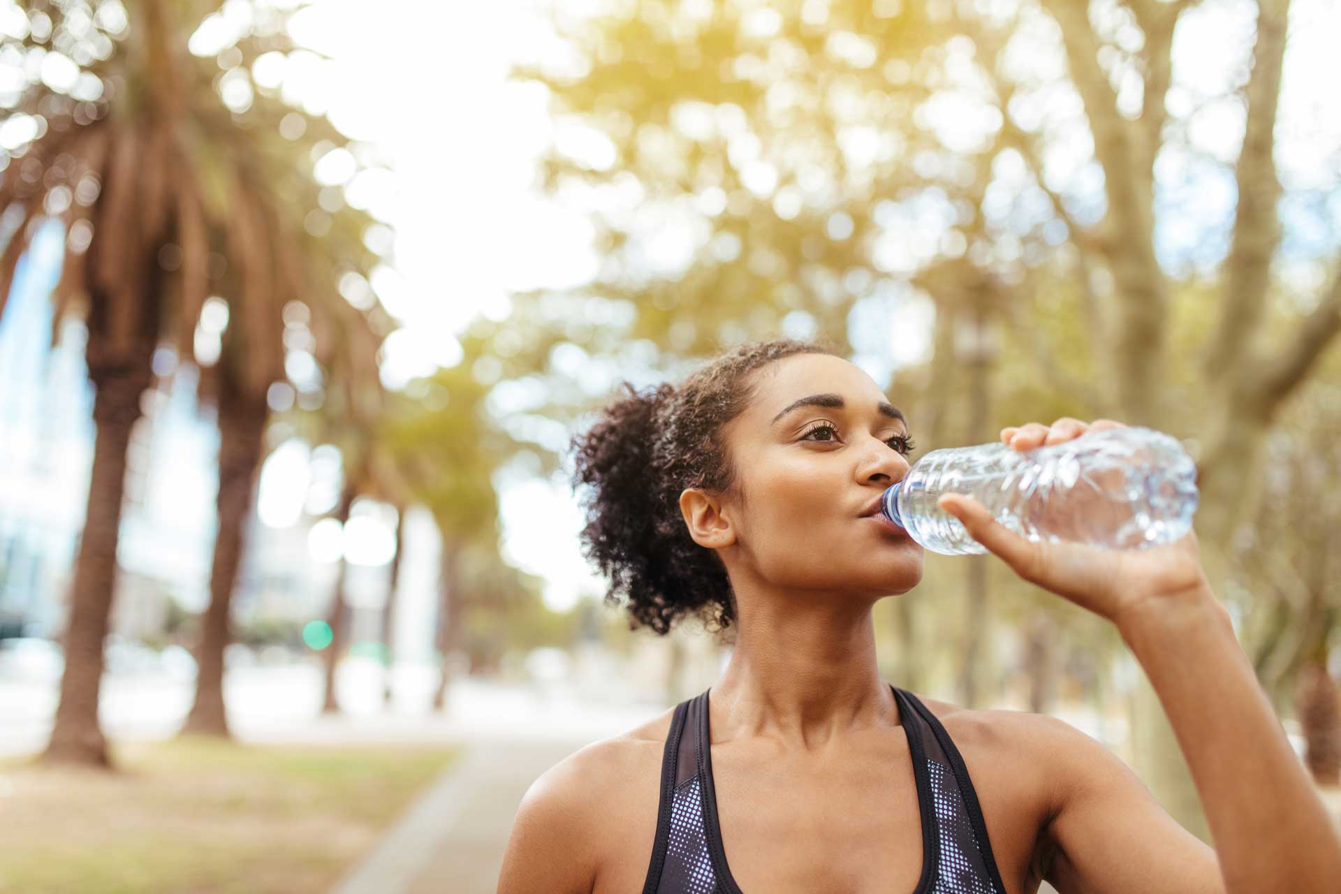 femme qui s'hydrate pendant son footing